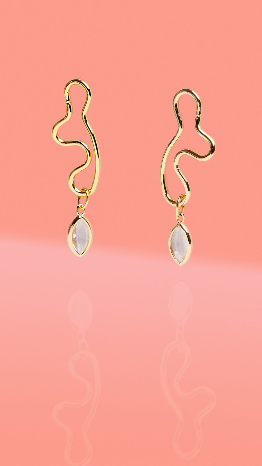 Aro dorado con dije de cristal transparente y forma abstracta
