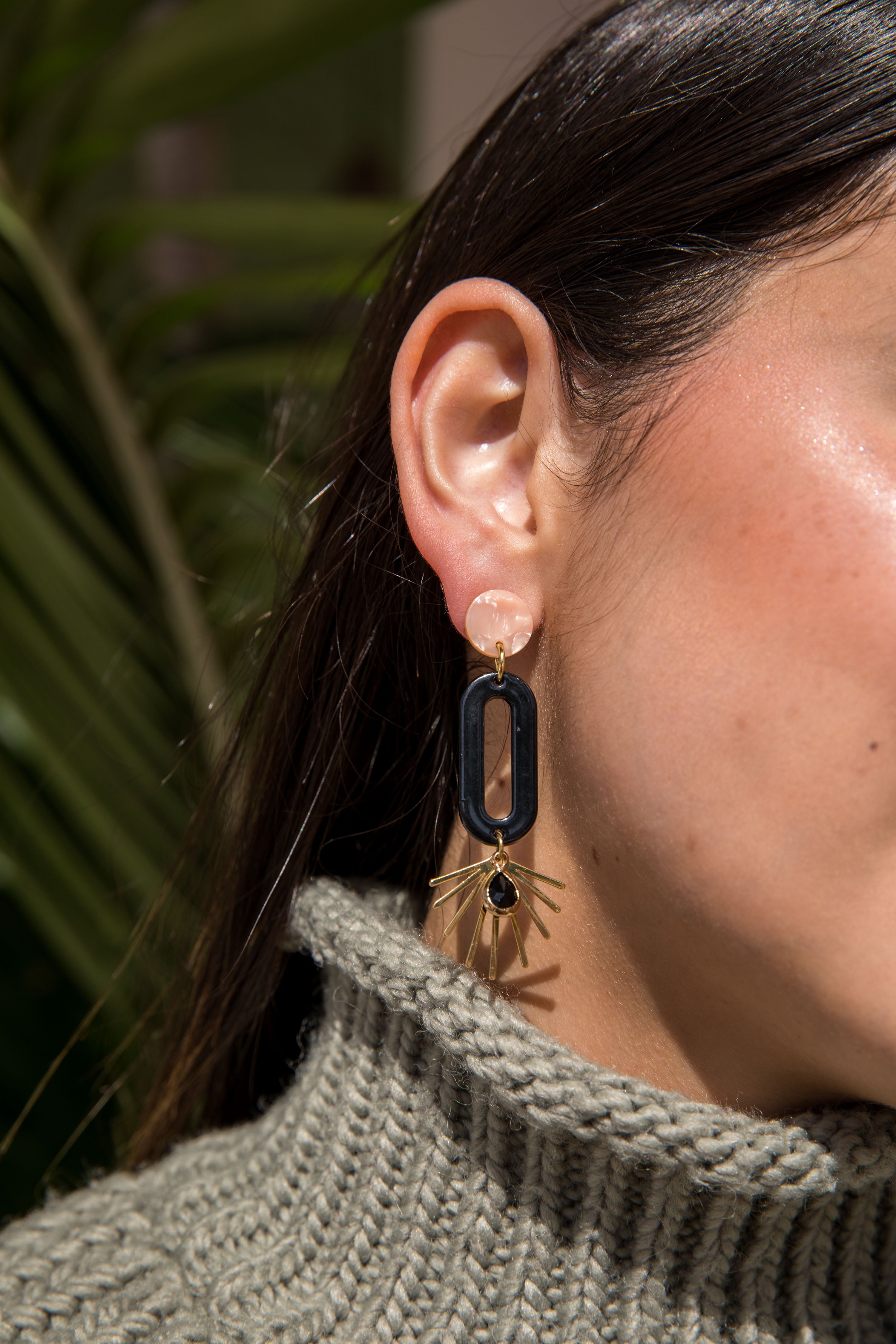 Pendiente de aro ovalado de resina negra con efecto de estallido de estrella